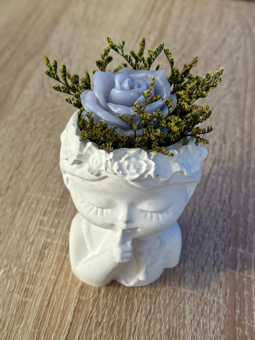 Cabeça de boneco em gesso com flor em cera