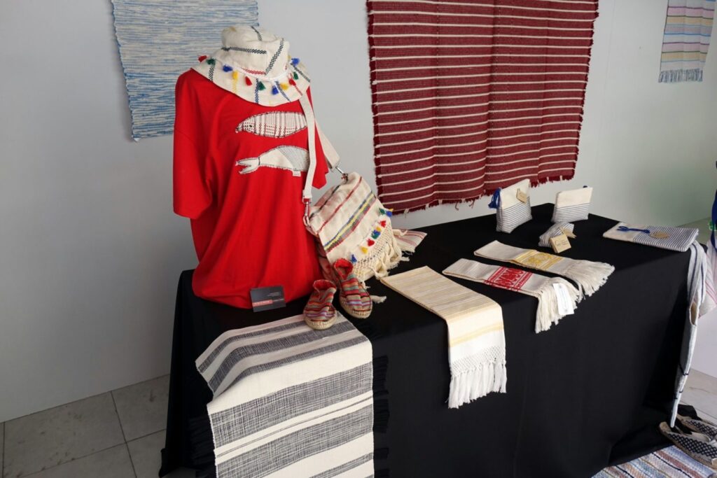 [:pt]Tecelagem de Almalaguês em exposição na montra do Welcome Centre do SHIFT[:en]Almalaguês weaving on display in the SHIFT Welcome Center window[:es]Tejido almalagués expuesto en el escaparate del Centro de Bienvenida SHIFT[:fr]Tissage d'almalaguês exposé dans la vitrine du centre d'accueil SHIFT[:zh]SHIFT 迎宾中心橱窗中展示的阿尔马拉古斯纺织品[:]