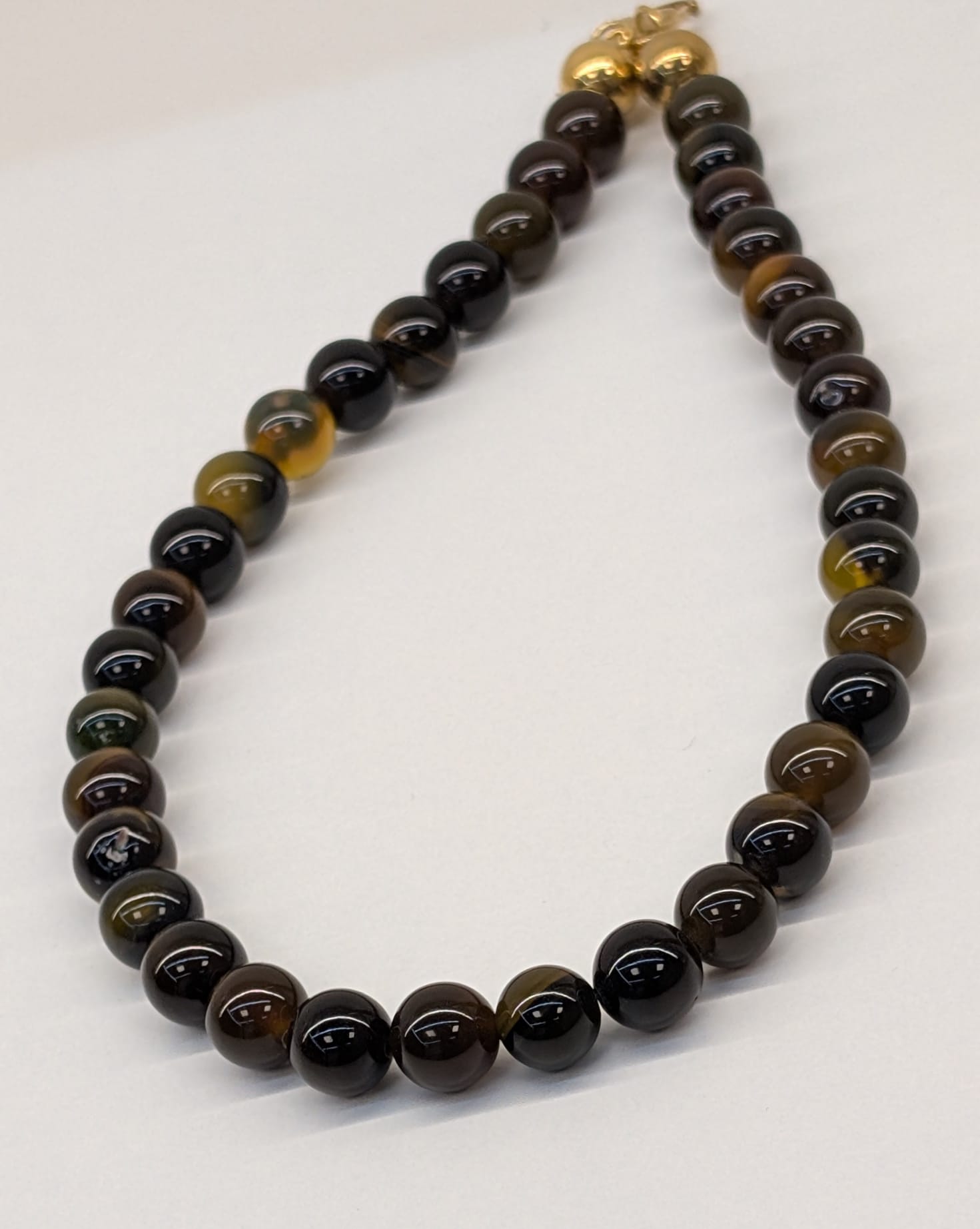 Colar em pedras castanho e aço dourado