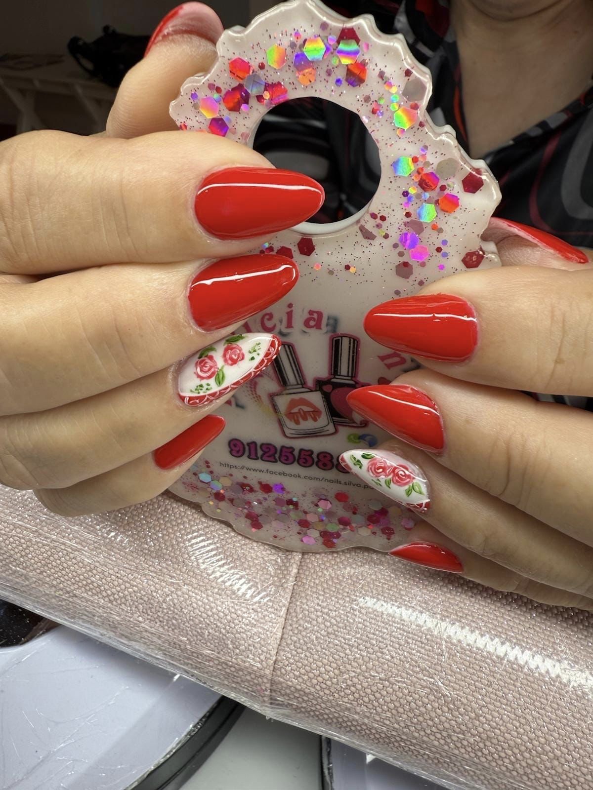 Unhas de gel com extensão em vermelho, com nail art floral de rosas em destaque, feitas na Patrícia Nails em Coruche.
